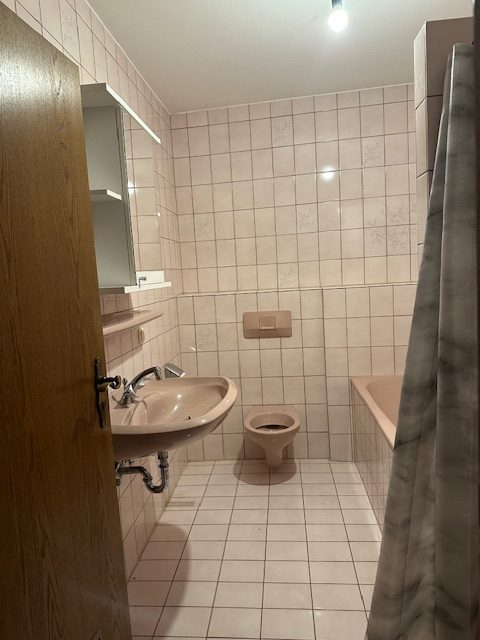Badezimmer mit Toilette und Waschbecken und Badewanne